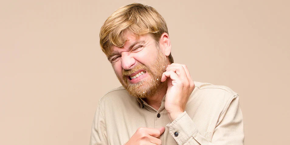A man experiencing beard irritation and discomfort, illustrating common beard problems and the need for proper beard care solutions.