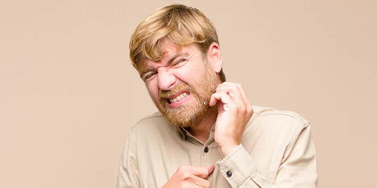 A man experiencing beard irritation and discomfort, illustrating common beard problems and the need for proper beard care solutions.